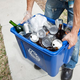 Man holding a recycling bin.
